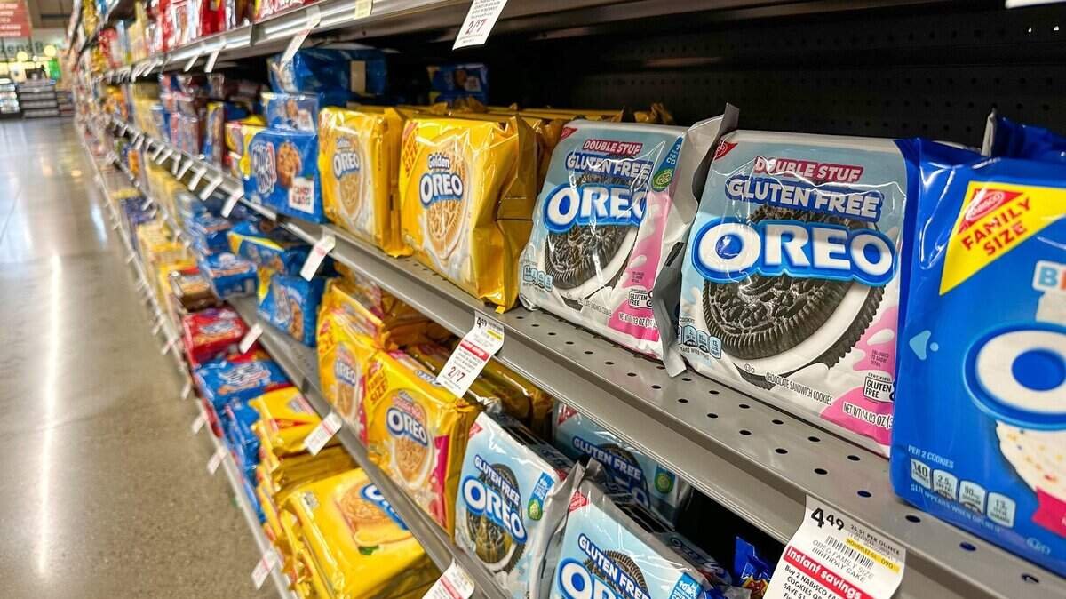 Wide shot of vibrant snack aisle in a supermarket with various chip bags on display.