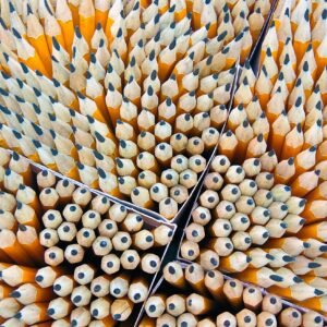 Close-up of sharpened wooden pencils organized in a geometric pattern.